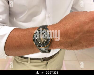 Alicante, Spagna - Giugno, 2021: Giovane uomo che indossa un orologio automatico in ceramica nera di lusso Foto Stock