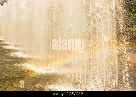 Una fontana funzionante nel parco con un arcobaleno dagli spruzzi. Foto Stock