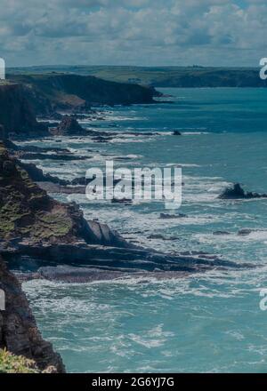 Costa frastagliata di Bude, Cornovaglia con motivo a V realizzato da Bude formazione arenaria letti nella piattaforma taglio-onda. Foto Stock