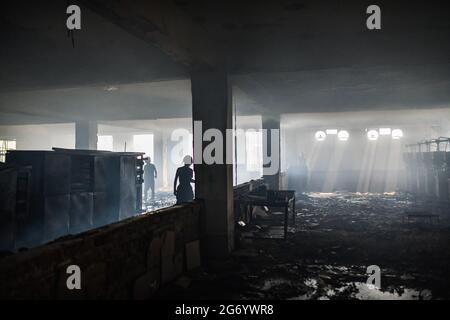 Narayanganj, Bangladesh. 09 luglio 2021. I vigili del fuoco ispezionano la fabbrica di Hashem Foods Ltd dopo lo scoppio di un incendio a Rupganj, distretto di Narayanganj, alla periferia di Dhaka. Almeno 52 persone sono state uccise, 25 altre ferite e molte sono temute intrappolate dopo un incendio massiccio infuriato in una fabbrica, la causa dell'incendio che ha avuto origine a un piano terra di un edificio a più piani della fabbrica non è ancora nota. Credit: SOPA Images Limited/Alamy Live News Foto Stock