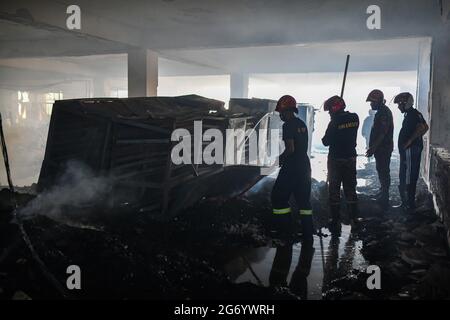 Narayanganj, Bangladesh. 09 luglio 2021. I vigili del fuoco ispezionano la fabbrica di Hashem Foods Ltd dopo lo scoppio di un incendio a Rupganj, distretto di Narayanganj, alla periferia di Dhaka. Almeno 52 persone sono state uccise, 25 altre ferite e molte sono temute intrappolate dopo un incendio massiccio infuriato in una fabbrica, la causa dell'incendio che ha avuto origine a un piano terra di un edificio a più piani della fabbrica non è ancora nota. Credit: SOPA Images Limited/Alamy Live News Foto Stock