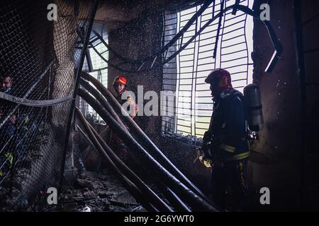 Narayanganj, Bangladesh. 09 luglio 2021. I vigili del fuoco ispezionano la fabbrica di Hashem Foods Ltd dopo lo scoppio di un incendio a Rupganj, distretto di Narayanganj, alla periferia di Dhaka. Almeno 52 persone sono state uccise, 25 altre ferite e molte sono temute intrappolate dopo un incendio massiccio infuriato in una fabbrica, la causa dell'incendio che ha avuto origine a un piano terra di un edificio a più piani della fabbrica non è ancora nota. Credit: SOPA Images Limited/Alamy Live News Foto Stock