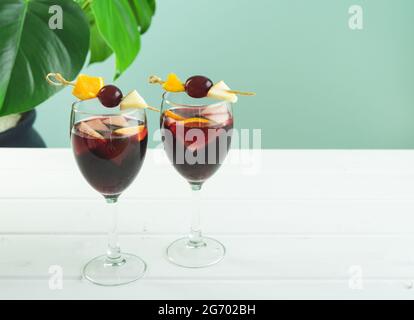 Occhiali sangria su sfondo bianco e verde. Bevanda tradizionale spagnola. Spazio di copia. Foto Stock