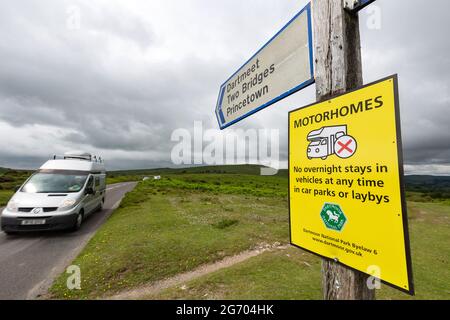 Una casa di guida nella foto che viaggia lungo una strada rurale attraverso il Dartmoor National Park a Devon, Regno Unito, dopo un cartello. Foto Stock