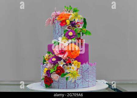 Torta di nozze viola con fiori colorati decorazione Foto Stock