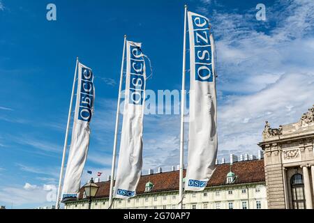 Bandiere dell'OSCE (Organizzazione per la sicurezza e la cooperazione in Europa) contro un cielo blu a Vienna, Austria Foto Stock