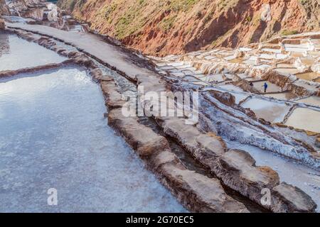 SALINAS, PERÙ - 21 MAGGIO 2015: Lavoratori a casse di estrazione del sale (Salinas) nella Valle Sacra degli Incas, Perù Foto Stock