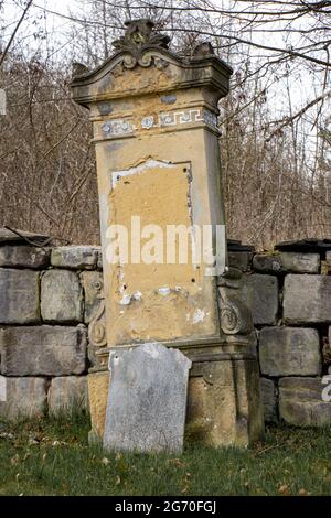 Una lapide danneggiata nel cimitero Foto Stock