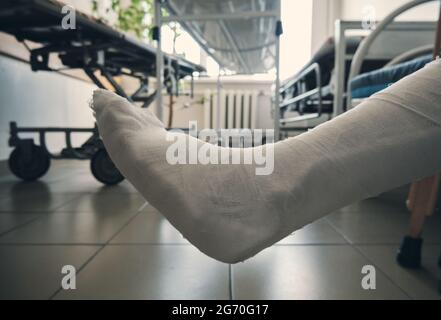 Gamba in un primo piano gesso schiavitù. Lesioni alle gambe. Perdita di mobilità. Riabilitazione dopo una frattura. Foto Stock