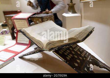 Ankara, Turchia-5 giugno 2021: Il manoscritto Corano e artista offuscato esecuzione calligrafia in turco ottomano (antico turco) Foto Stock