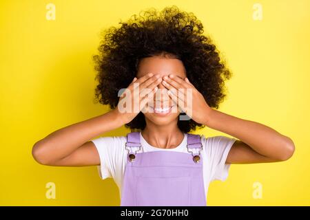 Foto di allegra palma da donna occhi chiusi sorriso togoloso indossare viola complessivo isolato giallo di colore sfondo Foto Stock