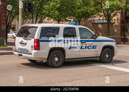 Holland, MI, USA - 8 giugno 2008: Primo piano di chevrolet bianco e blu macchina della polizia del tecnico prove all'incrocio. Verde fogliame. Foto Stock