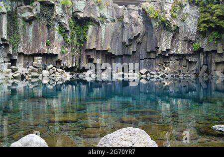 Incredibile acqua blu chiaro sotto la cascata di Cheonjiyeon nell'Isola di Jeju, Corea del Sud Foto Stock