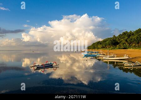 Spettacolare alba sulla spiaggia di Sanur e sulle tradizionali barche balinesi fisher man a Bali, Indonesia Foto Stock