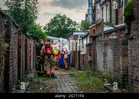 Manchester, Regno Unito. 09 luglio 2021. Vigili del fuoco visti in un vicolo posteriore per fermare l'incendio della casa a Failsworth.Greater Manchester Fire Service Block al largo di Norman Street, Failsworth dopo un incendio di casa in un appartamento su Manchester Road. I residenti dicono che il fuoco della casa è stato causato da un uomo che ha voluto commettere suicidio, tuttavia rapporti contrastanti anche mi è venuto che l'uomo stava cucinando. Due camion dei vigili del fuoco e un comandante dei vigili del fuoco hanno risposto alla scena. Credit: SOPA Images Limited/Alamy Live News Foto Stock