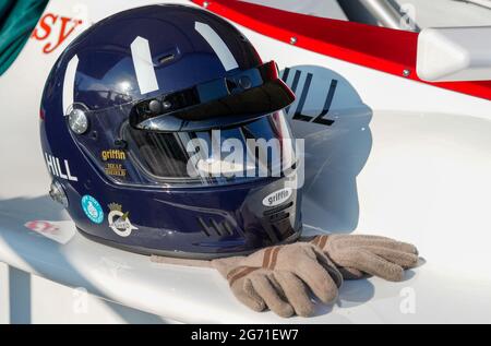 Un casco blu marino con flash bianchi a forma di remo e guanti da guida in pelle marrone indossati da Graham Hill, pilota da corsa F1. Festival della velocità 2021 Foto Stock