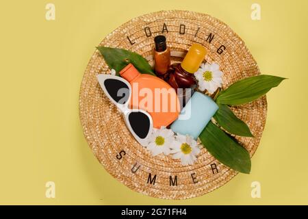 Cappellino estivo donna su sfondo giallo top view piatto spazio copia posa. Concetto di vacanza di viaggio estivo, elemento singolo. Testo ESTATE da lettere e f Foto Stock