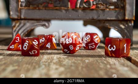 Primo piano di un set di dadi di gioco del ruolo in marmo arancione focalizzato sui dadi a 20 lati Foto Stock