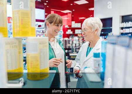Il cliente e Donna vendita di droga in negozio per discutere dei prodotti Foto Stock