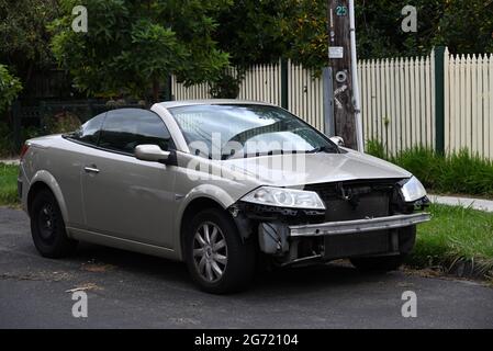 Una Renault Megane convertibile danneggiata, priva del paraurti anteriore, si trova parcheggiata in strada Foto Stock