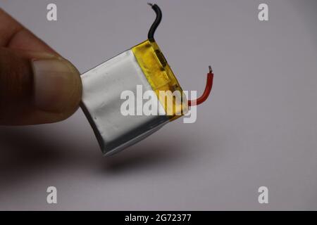 Batteria ai polimeri di litio che viene utilizzata per alimentare piccoli dispositivi elettronici chiamati anche batteria li-po in mano Foto Stock
