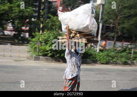 Dhaka, Bangladesh. 10 luglio 2021. Un lavoro quotidiano indossa una maschera per essere al sicuro dal COVID-19 durante il rigido blocco causato dall'epidemia. Anche se il blocco è in corso, ma le persone a basso reddito del paese stanno uscendo da casa in cerca di lavoro. Credit: Md. Rakibul Hasan/ZUMA Wire/Alamy Live News Foto Stock