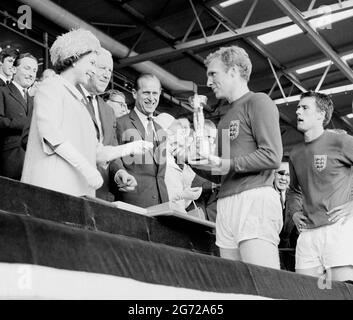 EMBARHOED AL 1830 SABATO 10 LUGLIO Foto del file datata 30/07/66 del capitano d'Inghilterra Bobby Moore che detiene il Jules Rimet Trophy, raccolto dalla regina Elizabetth II, dopo aver battuto la Germania Ovest nella finale della Coppa del mondo a Wembley, Londra. La Regina ha inviato una lettera al direttore di calcio inglese Gareth Southgate congratulandosi con lui e con la squadra di calcio inglese per aver raggiunto la finale UEFA Euro 2020, e mandando buoni auspici con 'la speranza che la storia registri non solo il vostro successo ma anche lo spirito, l'impegno e l'orgoglio con cui vi siete condotti'. Data di emissione: Sabato 10 luglio 2021. Foto Stock