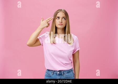 Qualcuno mi uccide per favore. Infastidito e annoiato alimentato cute giovane donna emotiva con pelle abbronzata chubby viso e capelli lisci palpebre che rotola il dito Foto Stock