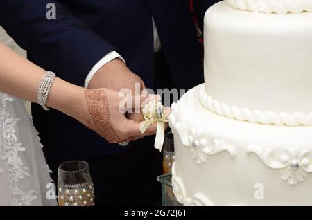 Una sposa e lo sposo è il taglio di loro torta nuziale Foto Stock