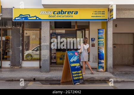 Colonia de Sant Jordi, Spagna; luglio 02 2021: Un negozio che vende biglietti per gite turistiche in barca all'isola di Cabrera, dove una donna sta cercando interno Foto Stock