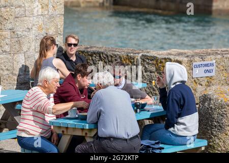 Porthleven, Cornovaglia, 10 luglio 2021, la gente cena Alfresco nel sole glorioso, Porthleven, Cornovaglia . La temperatura è stata di 18C, la previsione è per le docce tuose domani.Credit: Keith Larby/Alamy Live News Foto Stock