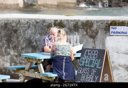 Porthleven, Cornovaglia, 10 luglio 2021, la gente cena Alfresco nel sole glorioso, Porthleven, Cornovaglia . La temperatura è stata di 18C, la previsione è per le docce tuose domani.Credit: Keith Larby/Alamy Live News Foto Stock