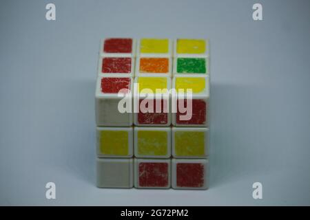 Un vecchio cubo casuale di Rubik con sfondo bianco Foto Stock