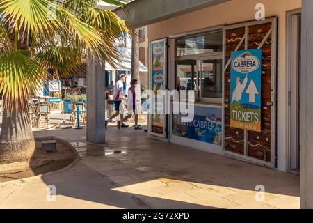 Colonia de Sant Jordi, Spagna; luglio 02 2021: Un negozio che vende biglietti per gite turistiche in barca all'isola di Cabrera, dove una donna sta cercando interno Foto Stock