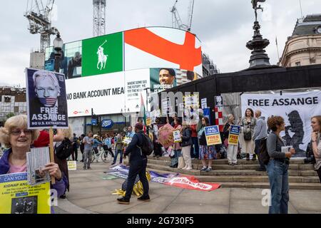 Londra, Regno Unito. 10 luglio 2021. Sostenitori di Julian Assange a Piccadilly Circus per una protesta che chiede la sua liberazione. Il fondatore di Wikileaks Assange è attualmente detenuto nel carcere di Belmarsh. La statua di Eros è attualmente imbarcata in vista della finale di Euro 2020 tra Italia e Inghilterra domani sera Wembley Stadium. Credit: Stephen Chung / Alamy Live News Foto Stock