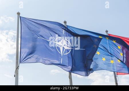 Bandiere dell'Unione europea e della NATO in cielo blu Foto Stock