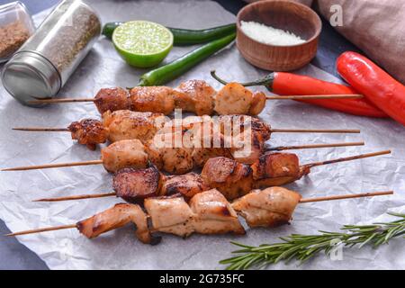 Spiedini con gustoso kebab di pollo su sfondo colorato Foto Stock