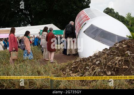 East Molesey, Surrey, Regno Unito. 8 luglio 2021. Le persone si accodano per vedere il famosissimo Global Impact Garden, l'estinzione di Designr Freecity o'Rourke. E' stata una giornata molto impegnativa oggi il giorno 4 del RHS Hampton Court Palace Garden Festival. In vero stile britannico, il sole splende al mattino, ma nel pomeriggio sono seguite docce pesanti come ombrelloni e ponchi erano gli accessori da non perdere. Credito: Maureen McLean/Alamy Foto Stock