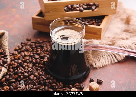 Caffè turco in cezve e fagioli su fondo grunge Foto Stock