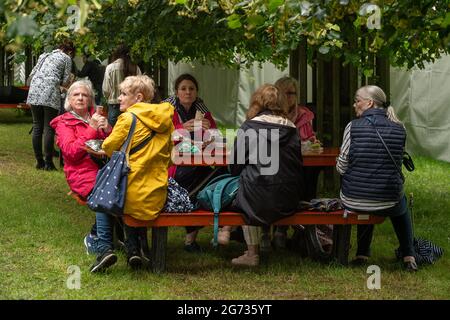 East Molesey, Surrey, Regno Unito. 8 luglio 2021. E' stata una giornata molto impegnativa oggi il giorno 4 del RHS Hampton Court Palace Garden Festival. In vero stile britannico, il sole splende al mattino, ma nel pomeriggio sono seguite docce pesanti come ombrelloni e ponchi erano gli accessori da non perdere. Credito: Maureen McLean/Alamy Foto Stock