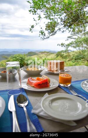 Sir John's Bungalow è la posizione ideale per una vista spettacolare e cibo e bevande deliziosi. Il Riverston Peak, situato sulle colline centrali dello Sri Lanka, può essere raggiunto viaggiando a circa 178 km da Colombo. Riverston offre alcune delle migliori viste sulla campagna circostante, nella misura in cui è chiamato il Mini Worldâs End. La zona offre la bellezza naturale dello Sri Lanka; fresco, verde e non inquinato da venditori, turisti, rifiuti ed edifici sgradevoli. Foto Stock