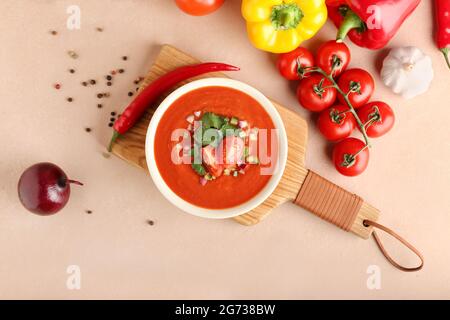 Ciotola con gustoso gazpacho e verdure su sfondo colorato Foto Stock