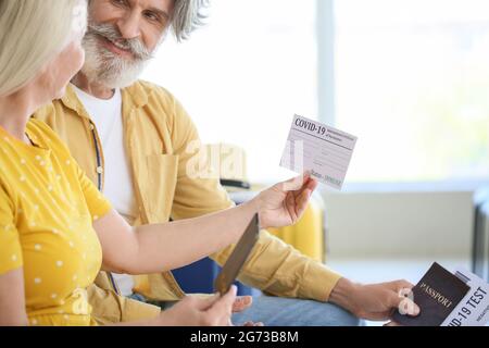 Turisti anziani con passaporto immunitario e risultati negativi covid-19 test all'aeroporto Foto Stock