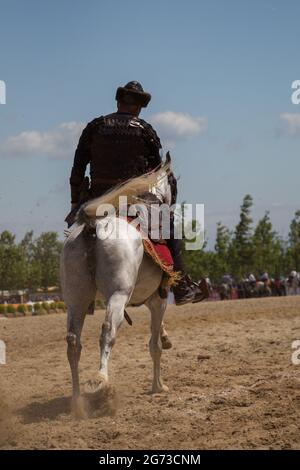 Tiro verticale di un arciere di cavallo in abiti etnici a cavallo Foto Stock