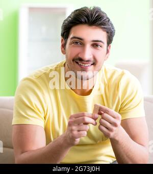 Il giovane uomo a casa dopo la lesione Foto Stock