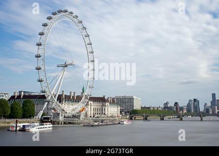 Il London Eye e la County Hall nel sole del pomeriggio visto dal Golden Jubilee Bridge. Il ponte di Westminster attraversa il Tamigi, Londra, Regno Unito Foto Stock