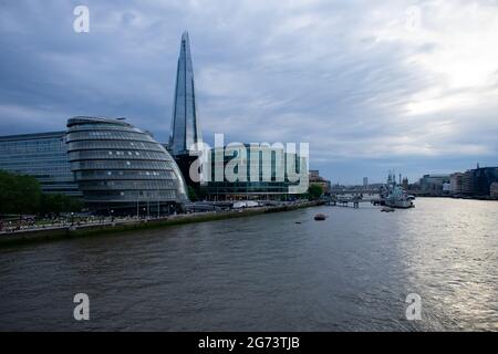 Guardando verso il basso dal Tower Bridge verso Shard, City Hall, HMS Belfast e London Bridge. Il cielo si riflette sul fiume prima che il sole tramonti. Foto Stock