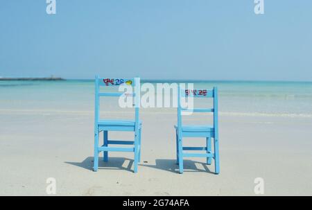 Sedie dipinte sulle rive della spiaggia di Woljeonri a Jeju Island, Corea del Sud Foto Stock