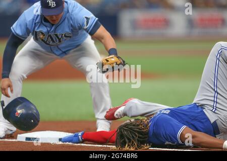 San Pietroburgo, Florida. USA; Toronto Blue Jays designato Hitter Vladimir Guerrero Jr. (27) tenta di scivolare di nuovo in primo, ma è taggato fuori da Tampa Foto Stock