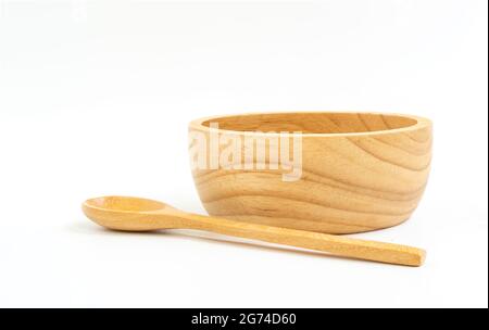 Ciotola e cucchiaio isolati di legno su sfondo bianco. Vista frontale della ciotola, cucchiaio messo davanti alla ciotola. utensili in legno per la salute e la natura Foto Stock